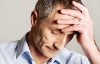 Man with Migraine Headache Touching His Forehead