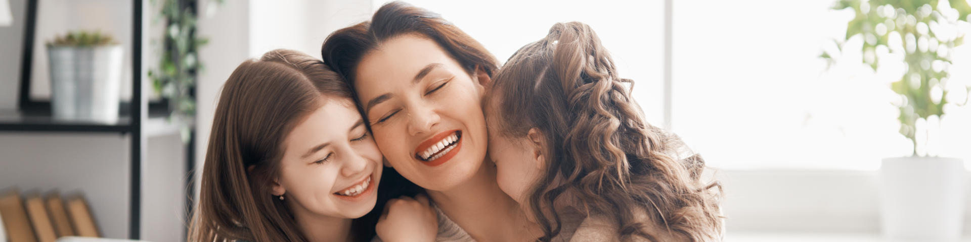 happy mother hugging her two cheerful little girls