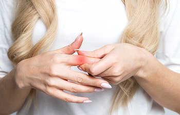 woman feels joint pain in fingers